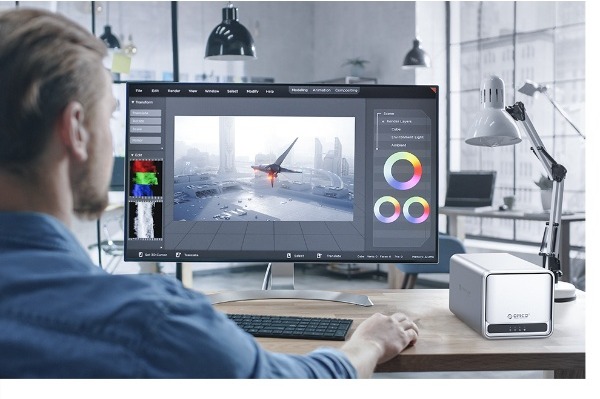 MetaCube ao lado de um monitor num posto de trabalho de edição